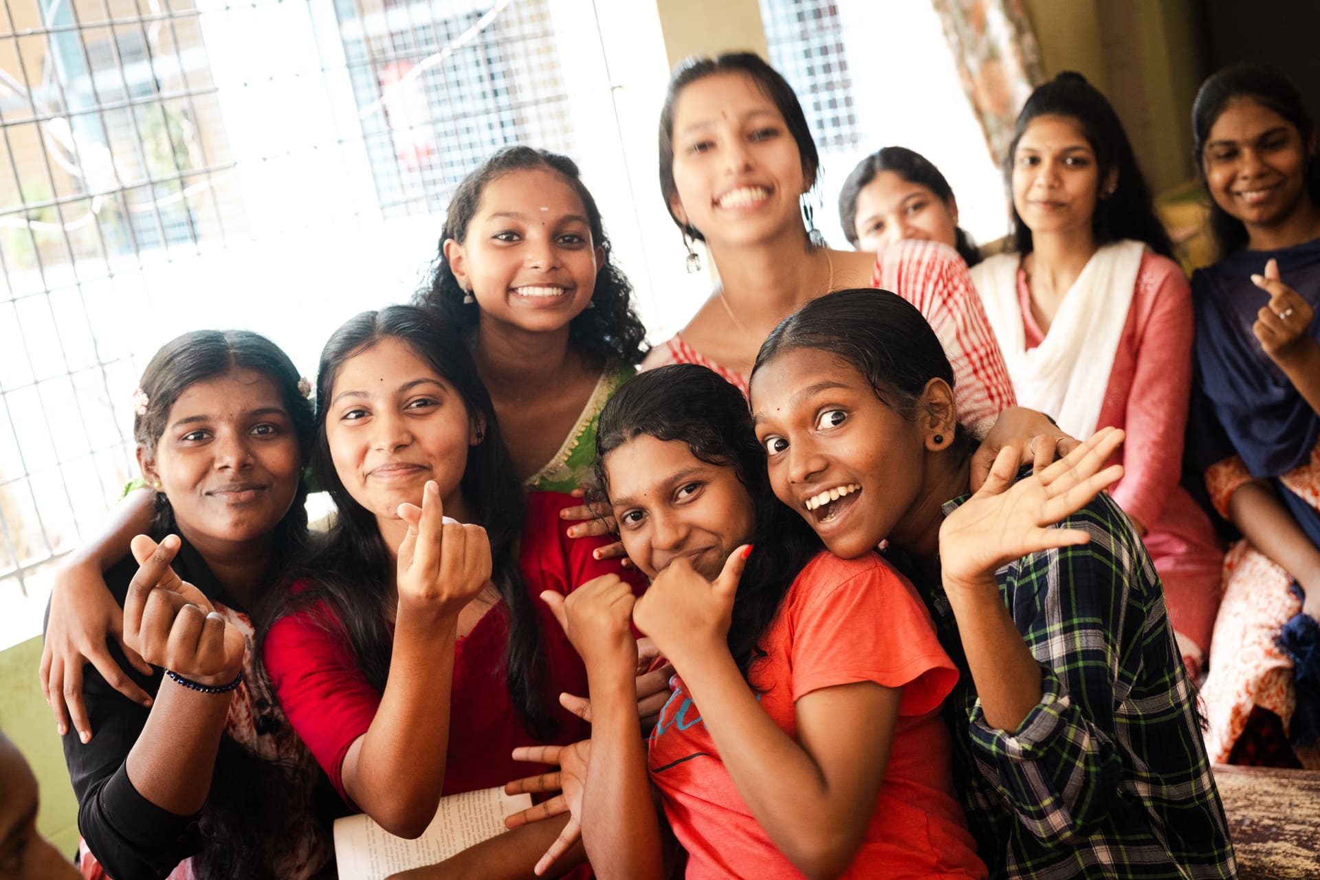 Groupe de jeunes filles indiennes qui sourient et font des coeurs avec les doigts