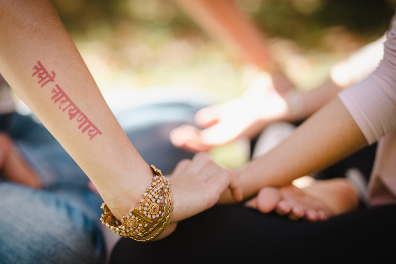 mains d'une professeure de yoga en train de guider une élève